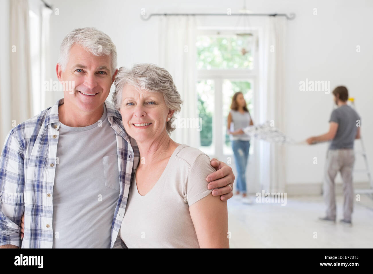 Anziana coppia sorridente insieme in uno spazio soggiorno Foto Stock