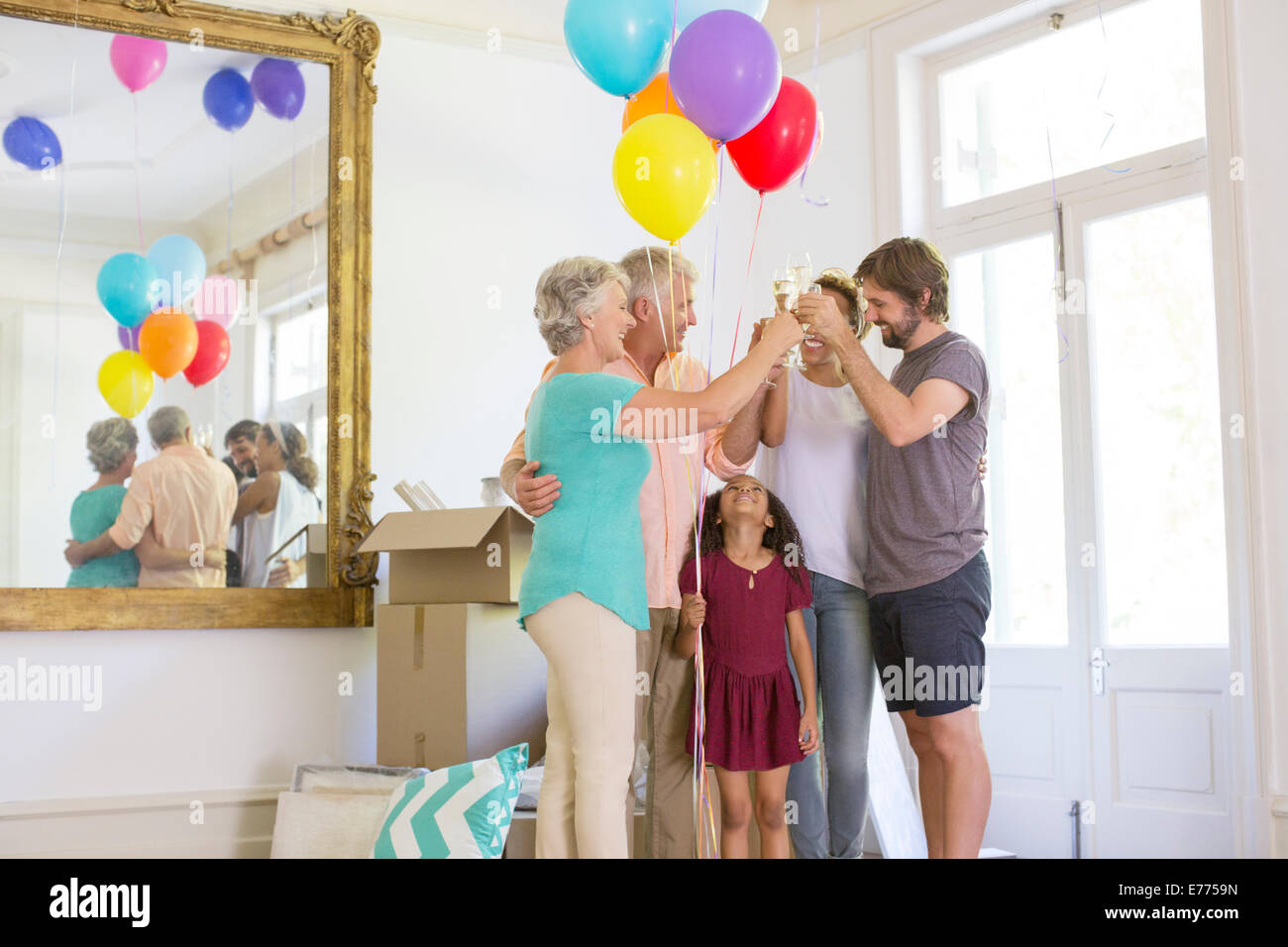 Famiglia celebrando con bevande e palloncini Foto Stock