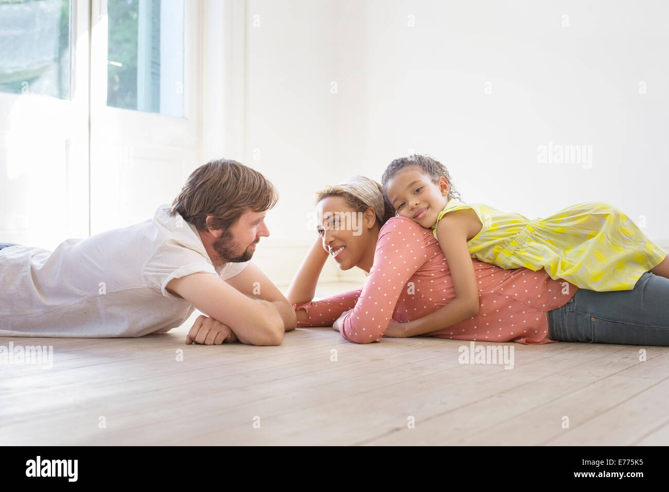 Famiglia posa sulla terra insieme in uno spazio soggiorno Foto Stock