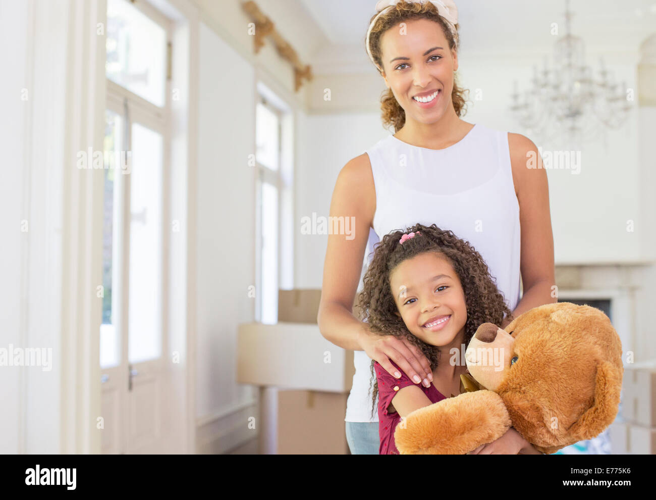 Madre e figlia sorridere mentre l'innesto orsacchiotto Foto Stock