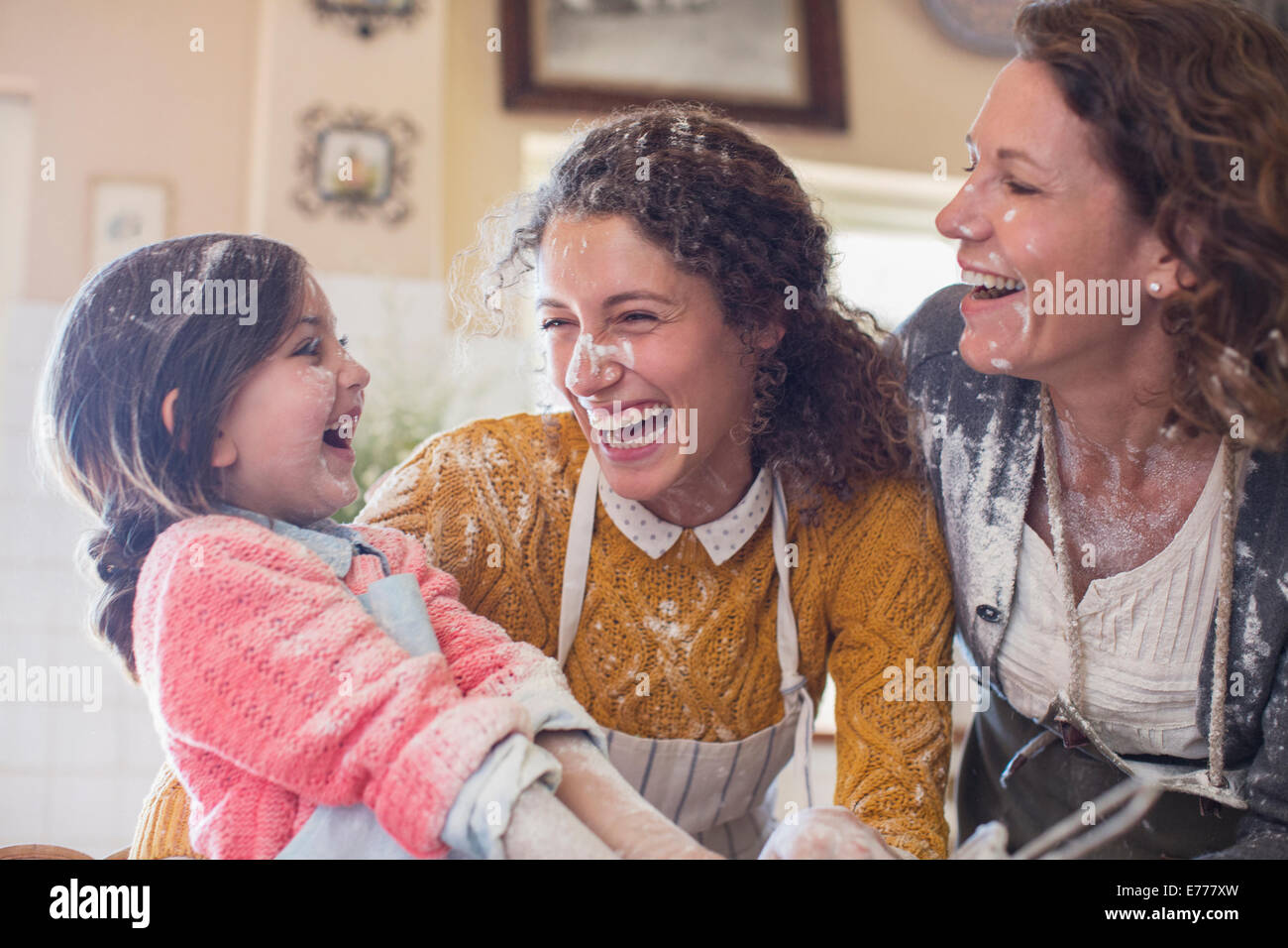 Tre generazioni di donne giocando in cucina Foto Stock