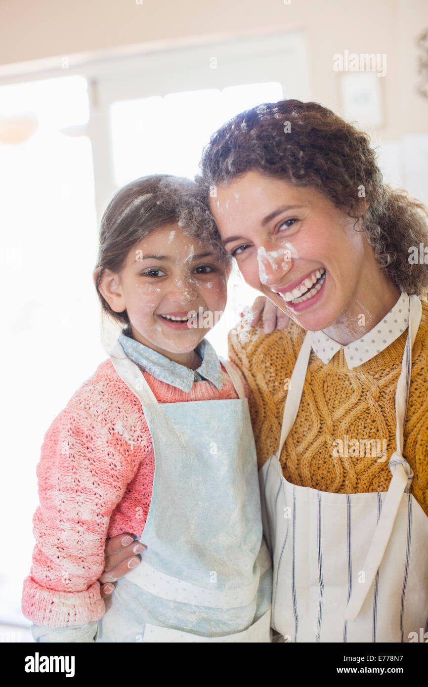 Madre e figlia giocando con la farina in cucina Foto Stock