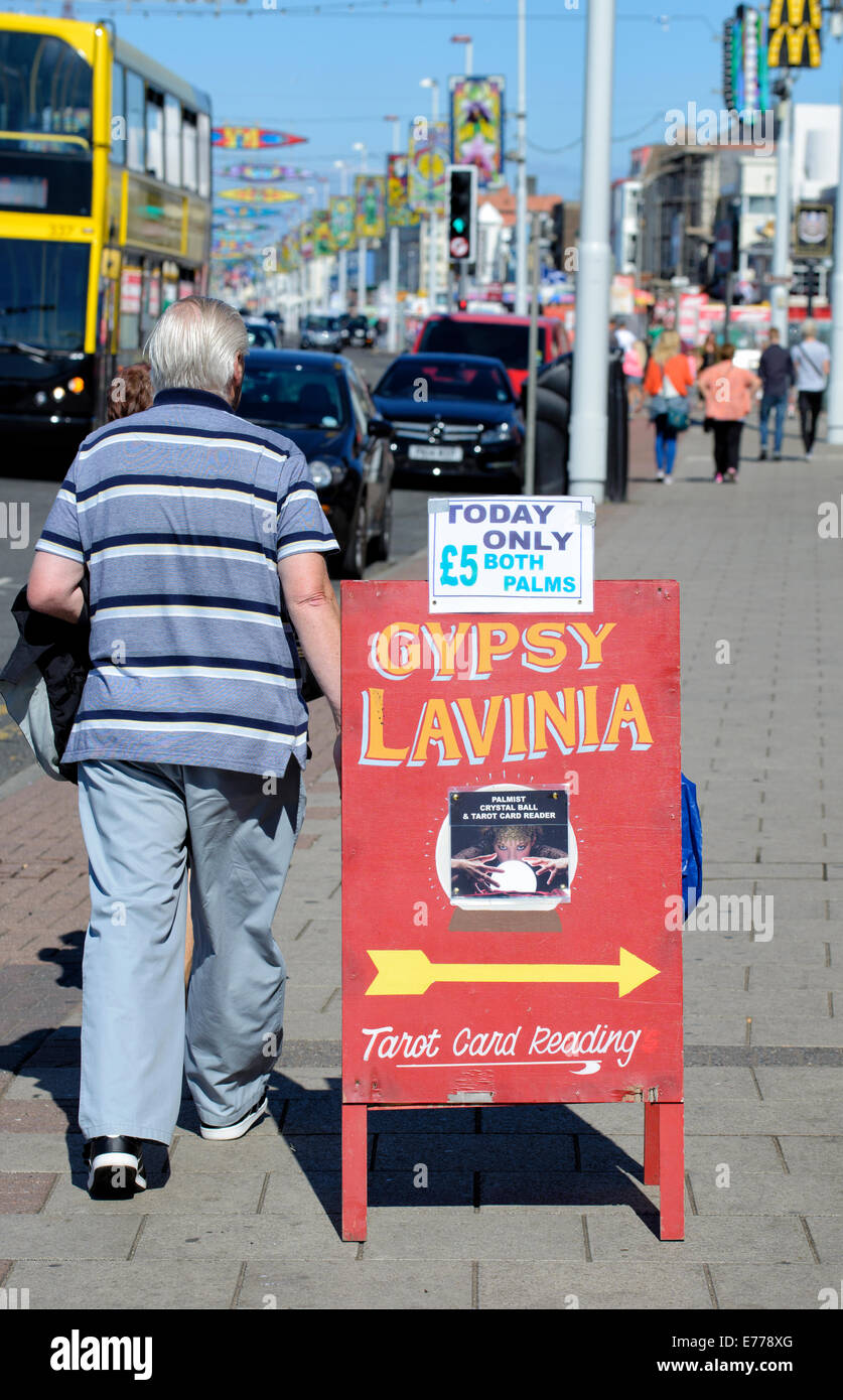Uomo che cammina passato scheda sul lungomare di Blackpool pubblicità Gypsy Lavinia Foto Stock
