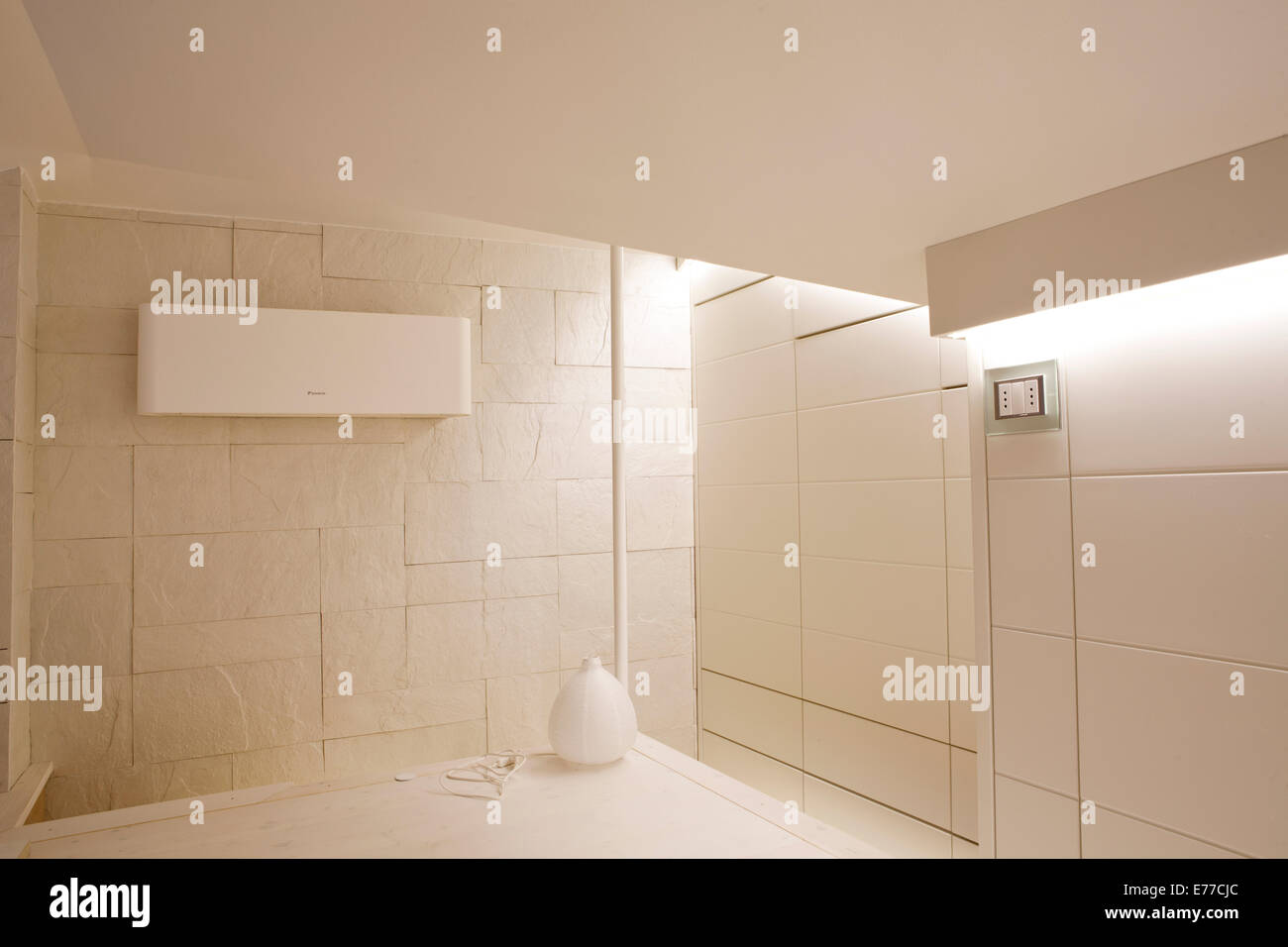 Interior design color crema muro di pietra, bianco nascosto guardaroba, lampada Foto Stock