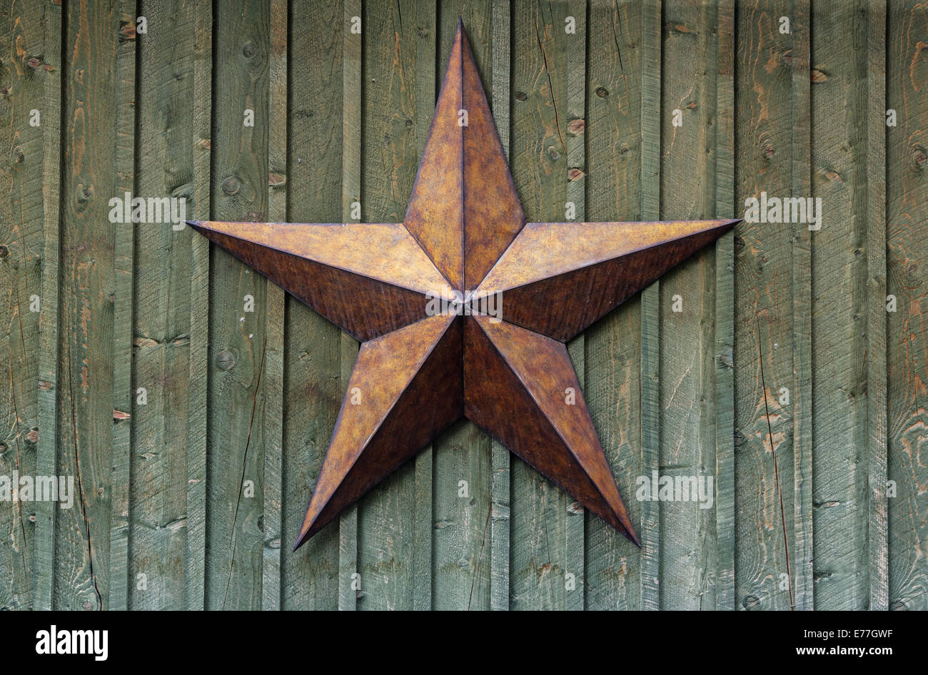 Metallo stella a cinque punte su una ruvida parete in legno Foto Stock
