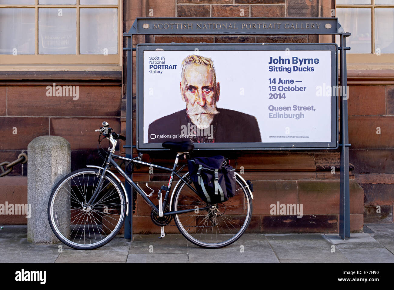 Una bicicletta attaccato ad un annuncio per un John Byrne mostra presso la Scottish National Portrait Gallery di Edimburgo, Scozia, Regno Unito Foto Stock