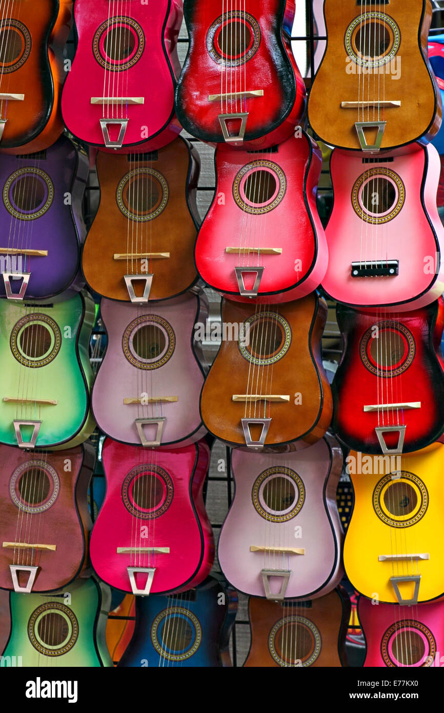 Diverse chitarre di diversi colori appesi in fila su una parete. Foto Stock