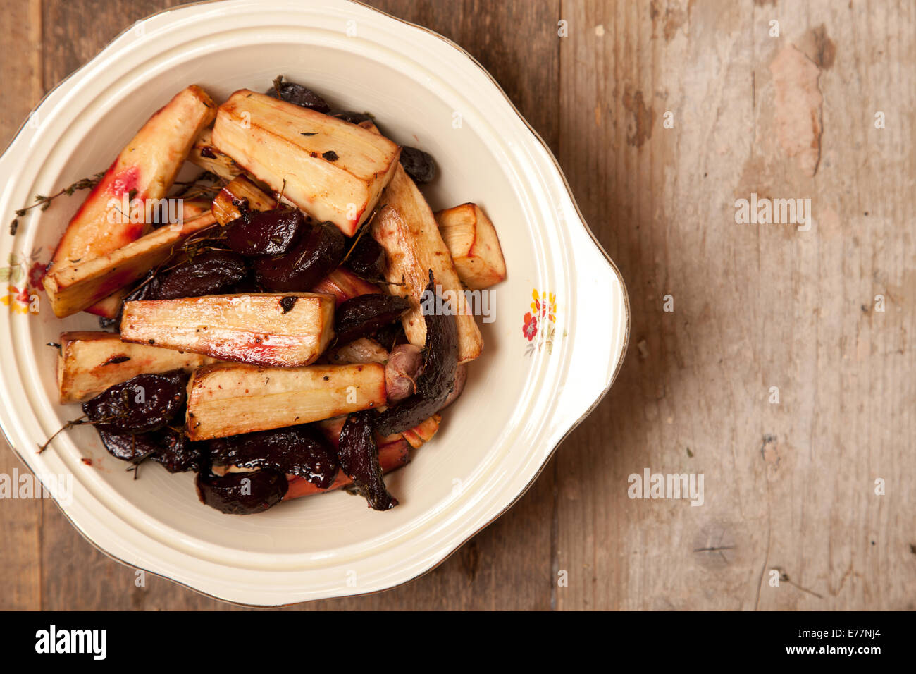 Arrosto di pastinaca e barbabietola in una ciotola sul tavolo di legno Foto Stock