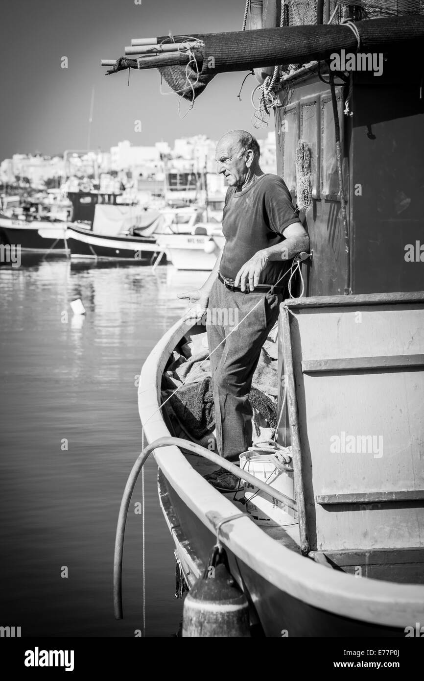 La mattina presto al porto di Marsaxlokk a Malta dove i pescatori possono essere trovati accudire barche Foto Stock