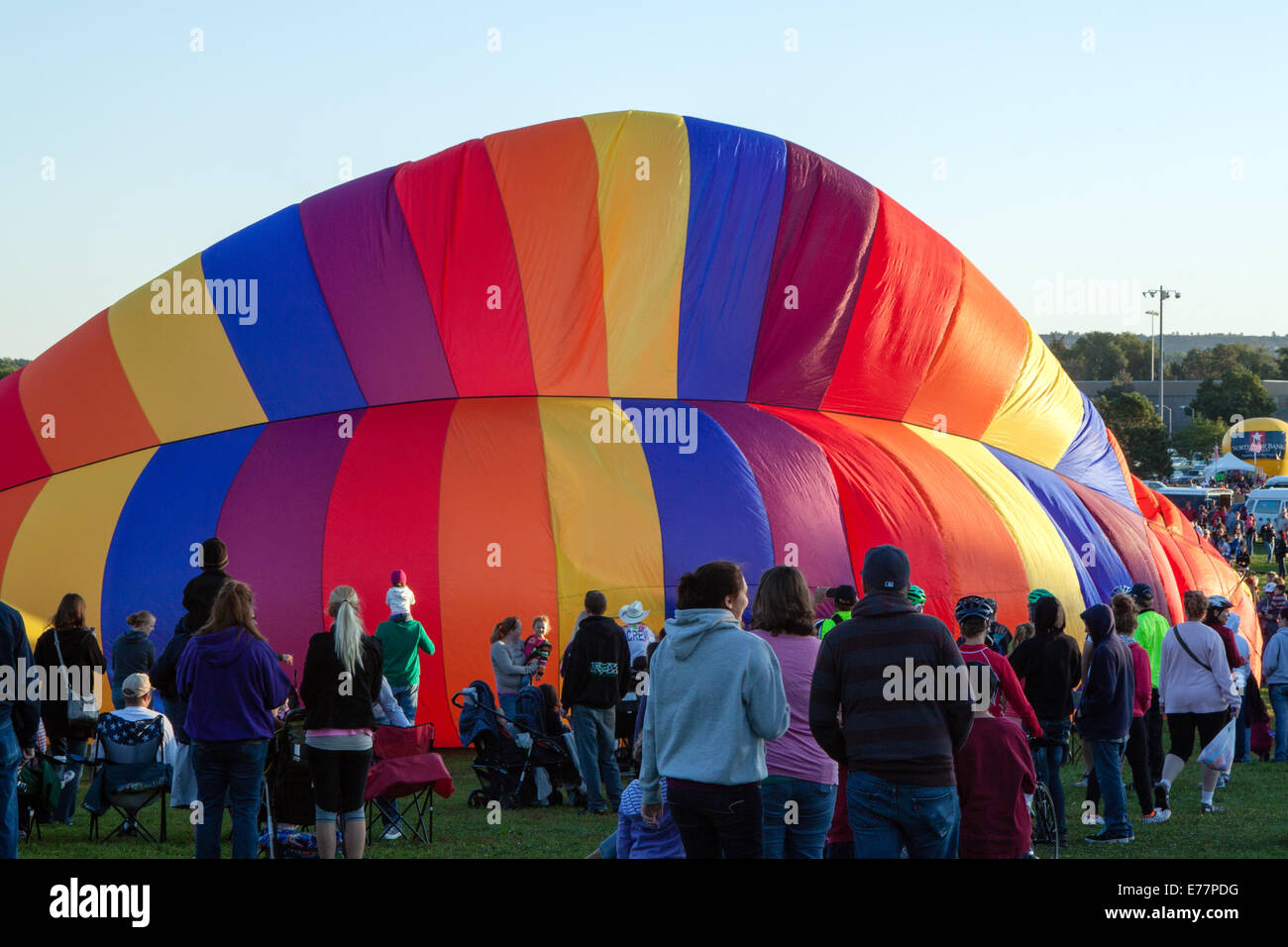 Una folla guarda come un arcobaleno colorato di aria calda palloncino viene gonfiato in Colorado Springs, CO Foto Stock