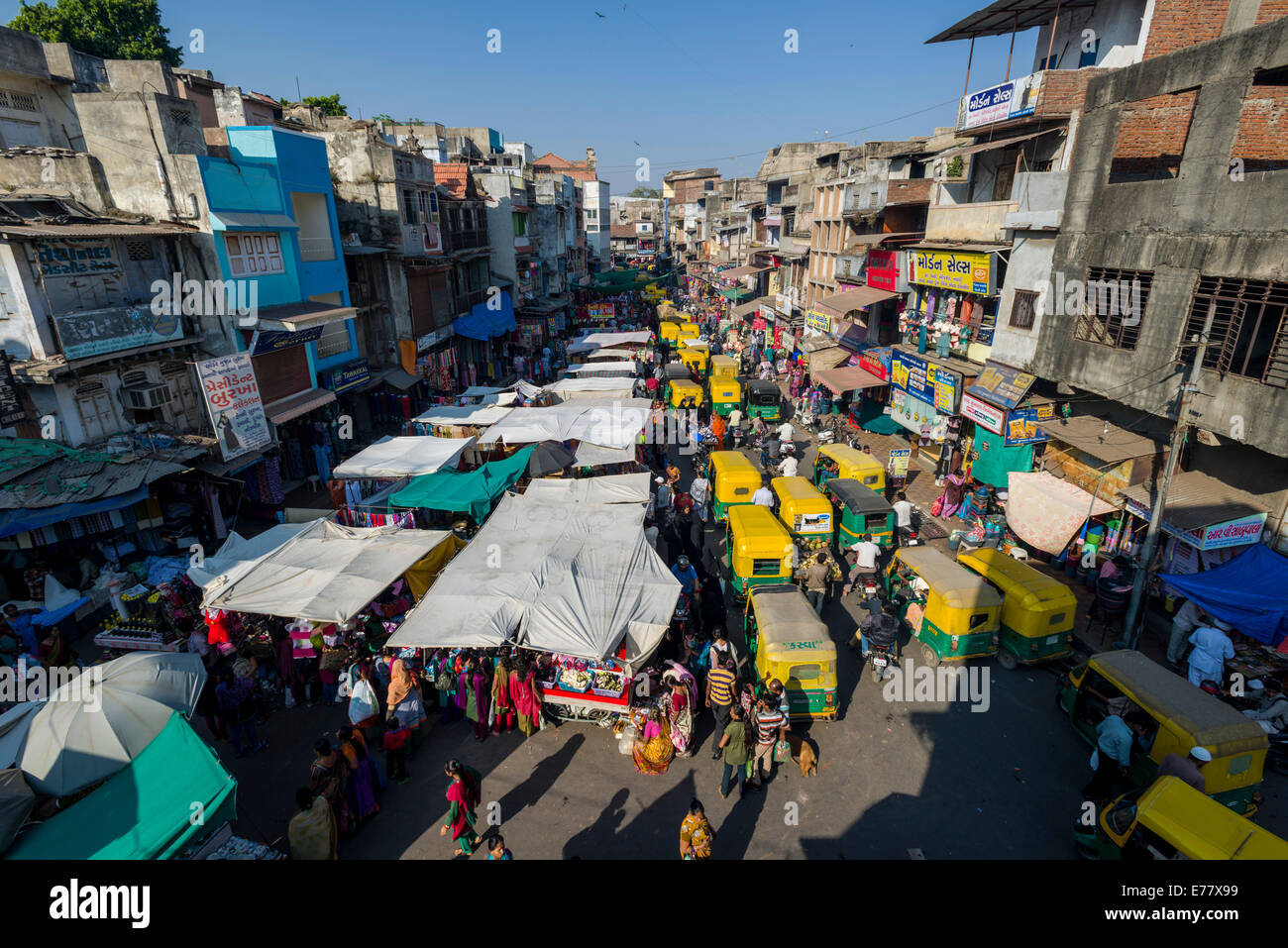Una strada affollata con negozi e il traffico nella città vecchia area di mercato, Ahmedabad, Gujarat, India Foto Stock