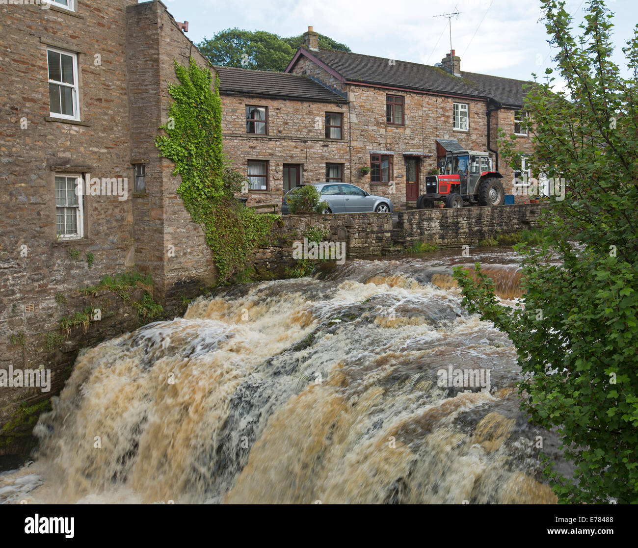 Acque di schiumatura della pittoresca Gayle Beck cade versando tra la storica cottage in pietra al villaggio di Hawes nello Yorkshire Inghilterra Foto Stock