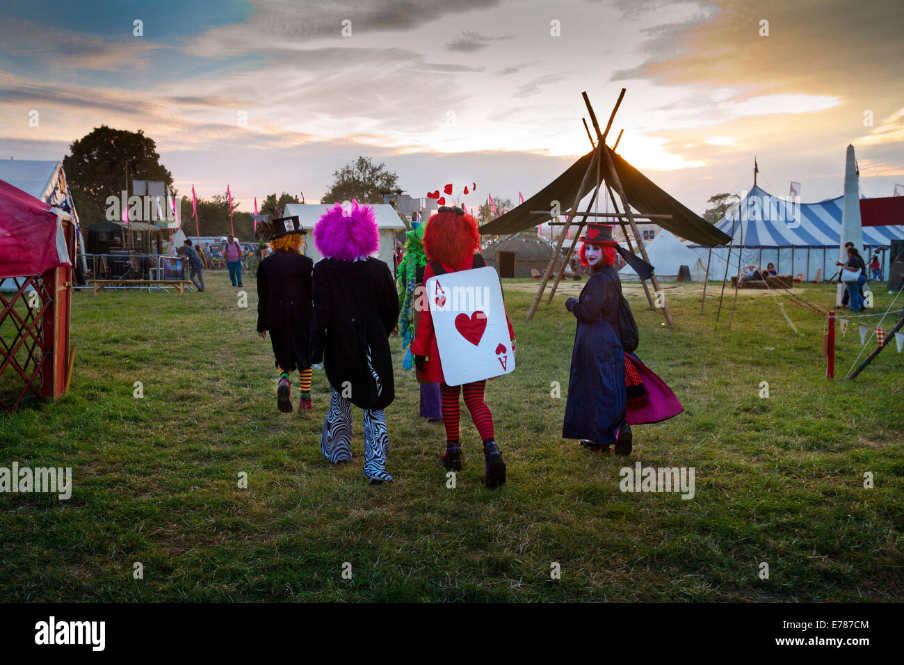 Vestito come Alice nel paese delle meraviglie, i frequentatori del festival a piedi attraverso il greenfields di Glastonbury Festival 2014 Foto Stock