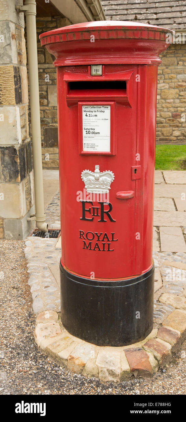 Tradizionale in rosso cassetta postale della British Royal Mail servizio postale sul marciapiede in villaggio inglese Foto Stock