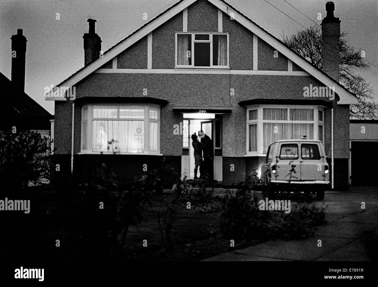 L'uomo lasciando per lavorare all'alba, kissing moglie addio alla porta di un Sidcup bungalow, nel sud di Londra sobborghi. Foto Stock