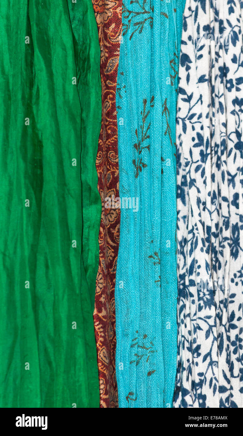 Tessuti in verticale. Assortimento di tessuti in tema di organico - di seta verde, rosso lana indiano, turchese di reticella metallica di cotone e cotone bianco Foto Stock