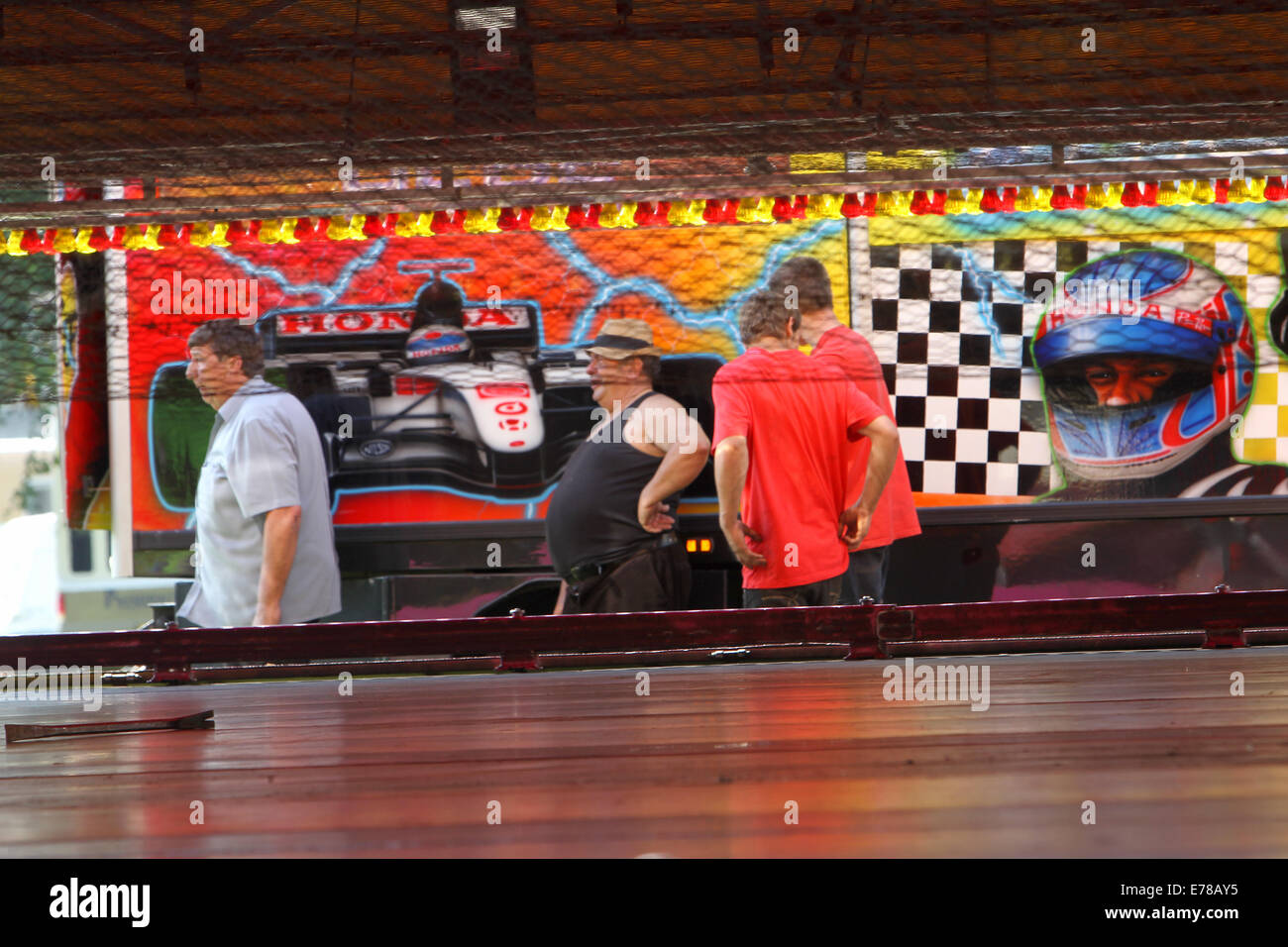 Witney, Oxfordshire, Regno Unito, 9 settembre 2014. Fiera dei lavoratori si prendono una pausa dalla impostazione di un dodgem ride in sole caldissimo in preparazione per la festa di Witney questo fine settimana. La festa annuale di Santa Maria è stato tenuto dal 1243 per commemorare il re-dedicazione della chiesa di Santa Maria quando il Vescovo ha dato un cervo al rettore di modo che la gente della città potrebbe festeggiare l'occasione. Oggi un arrosto di maiale sulla Chiesa ancora verde segna questa parte della tradizione accanto alle giostre e baracconi, chioschi, musica ed eventi sportivi Credito: Ric Mellis/Alamy Live News Foto Stock