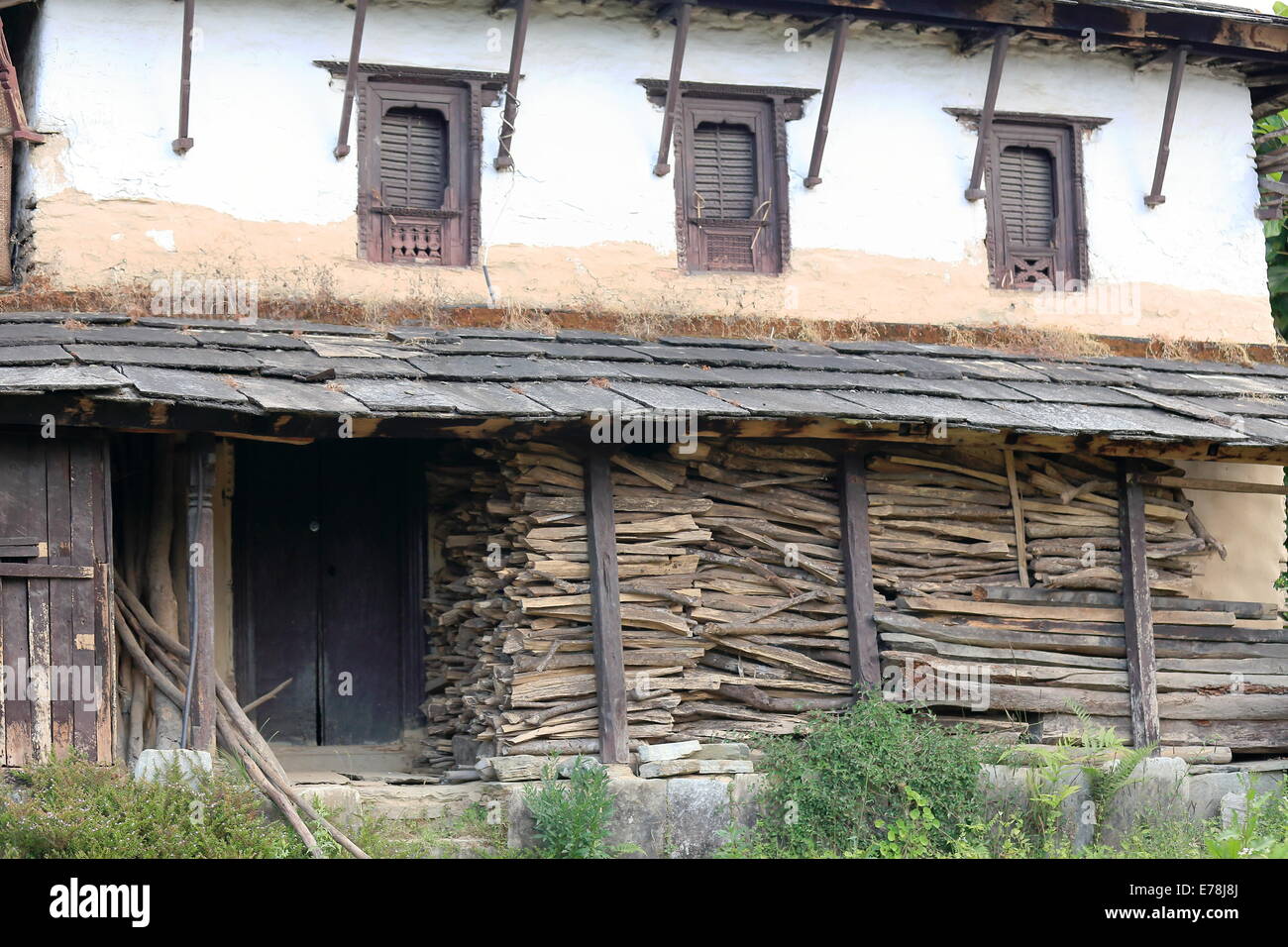 Bianco tradizionale e verniciato di colore marrone-pietra-legna da ardere affollata portico gurung townhome. Ghandruk villaggio sul Annapurnas Tour Foto Stock