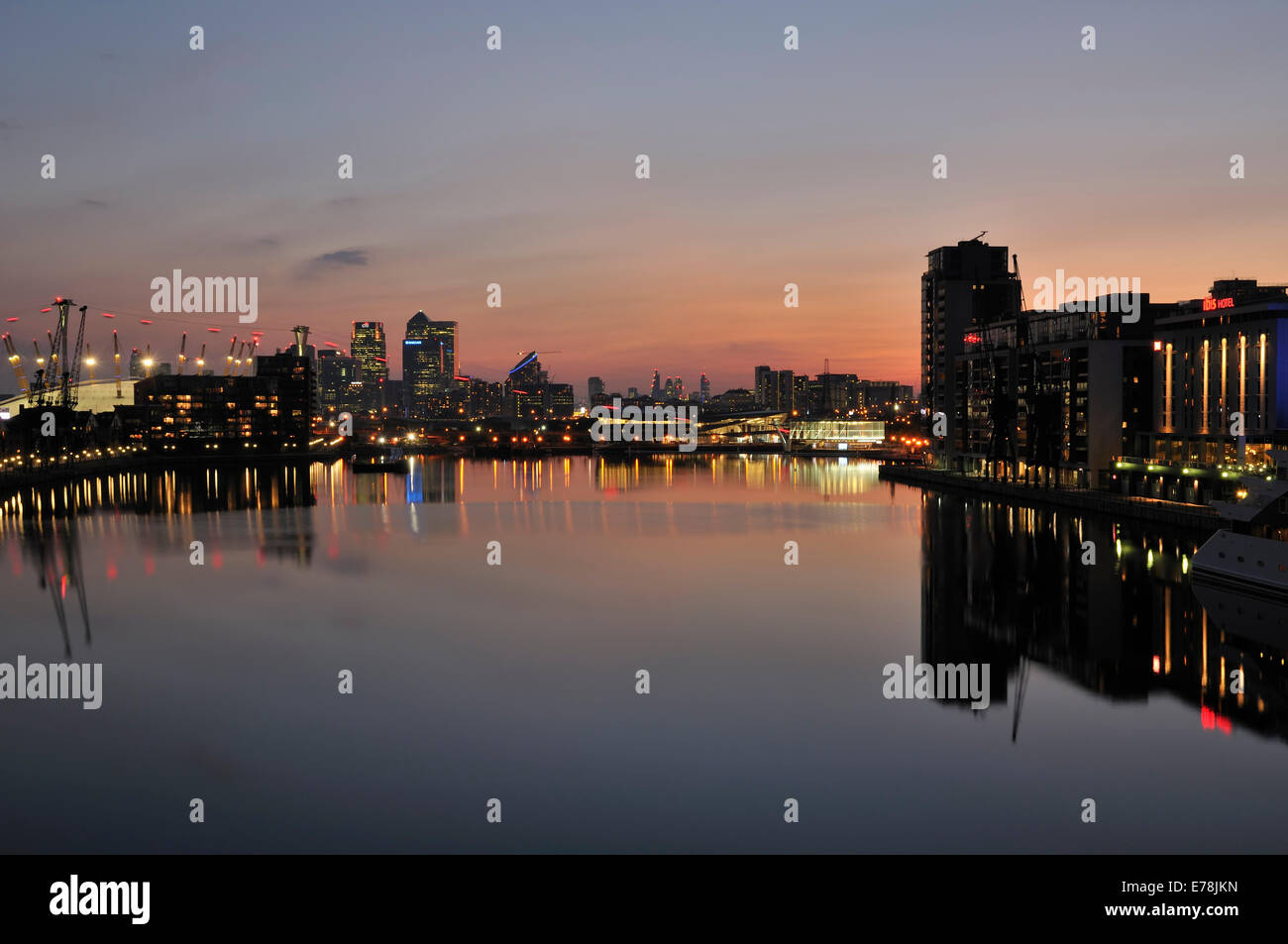 Royal Victoria Dock, Londra UK, al tramonto, guardando verso l'Isola dei Dogs, con riflessi di edifici illuminati Foto Stock
