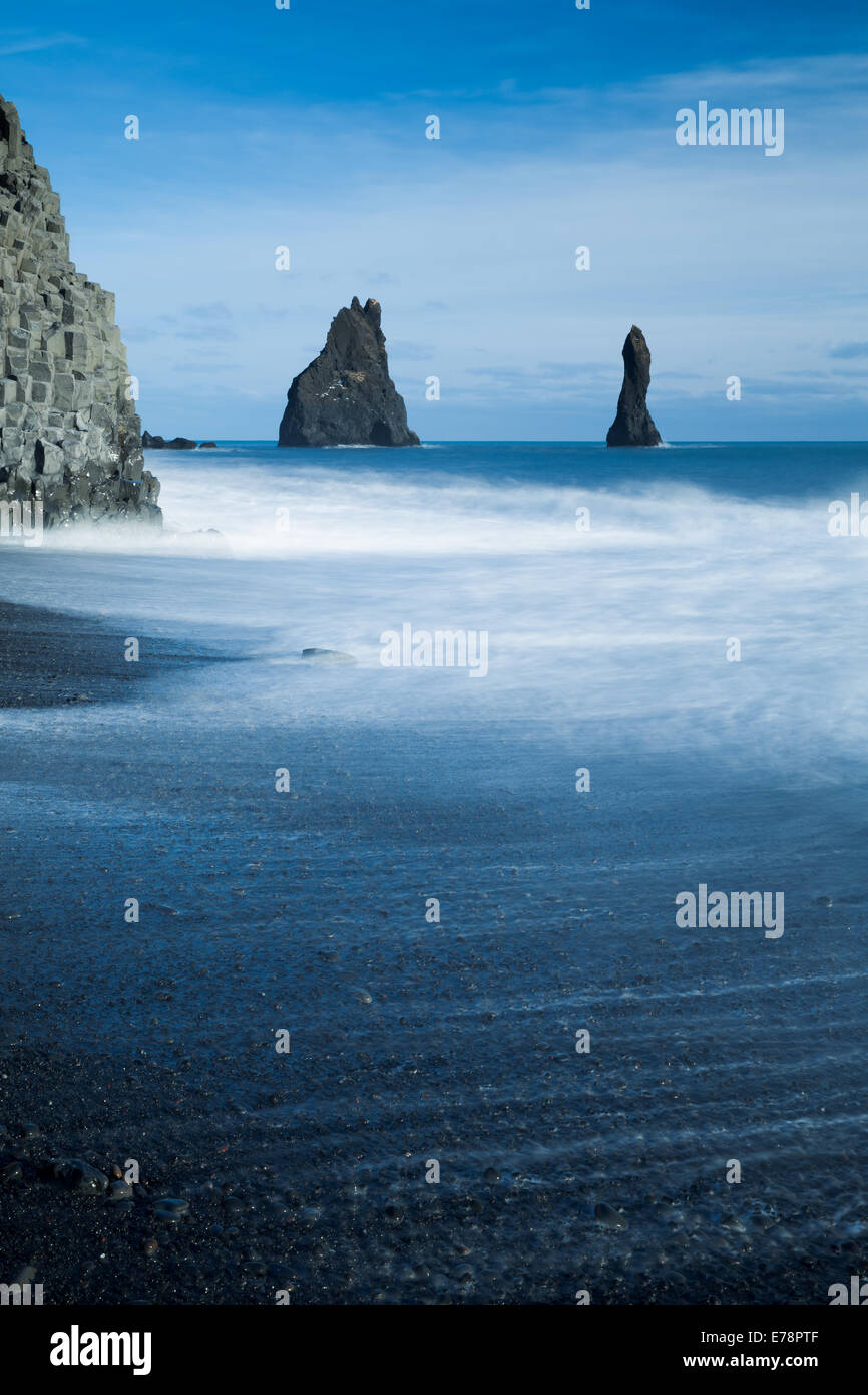 Il basalto Reynisdrangar pile di mare e il Reynisfjara spiaggia di sabbia nera vicino al villaggio di Vík í Mýrdal, sud dell'Islanda Foto Stock