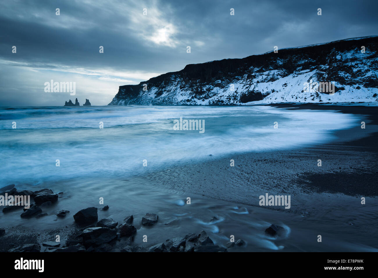 La spiaggia di sabbia nera a Vík í Mýrdal in inverno, con il basalto Renisdrangar mare pile al di là, sud dell'Islanda Foto Stock