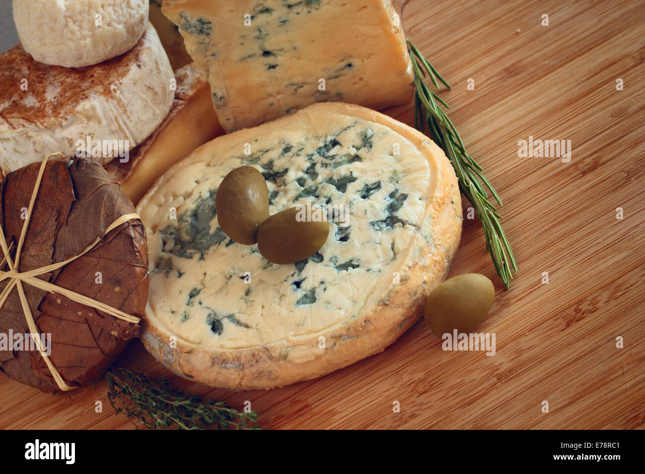 Il formaggio e le olive composizione sul tavolo di legno Foto Stock