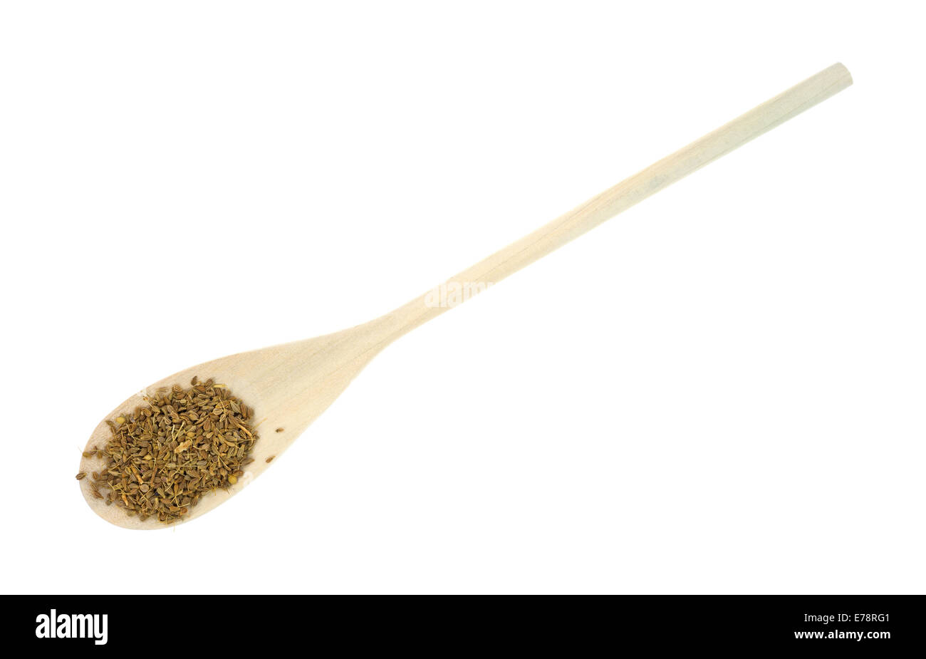 Un lungo cucchiaio di legno con i semi di anice su uno sfondo bianco. Foto Stock