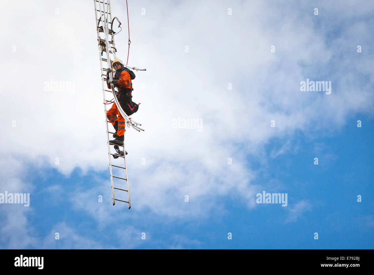 Overhead cavo di trasmissione installer installazione cavo isolato sul braccio trasversale di una nuova costruzione di trasmissione ad alta tensione Foto Stock