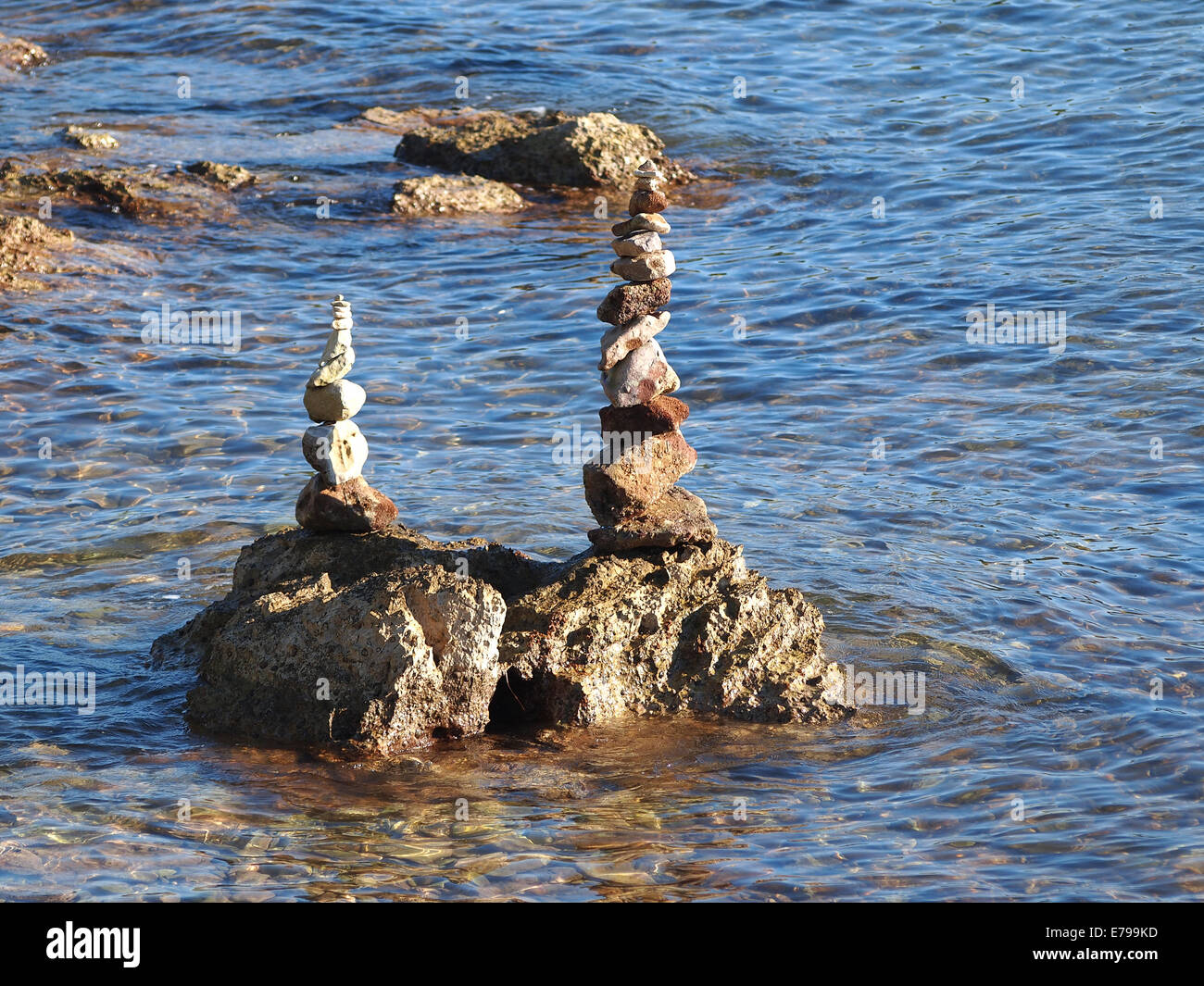 Pila di pietre rotonde su una riva del mare Foto Stock