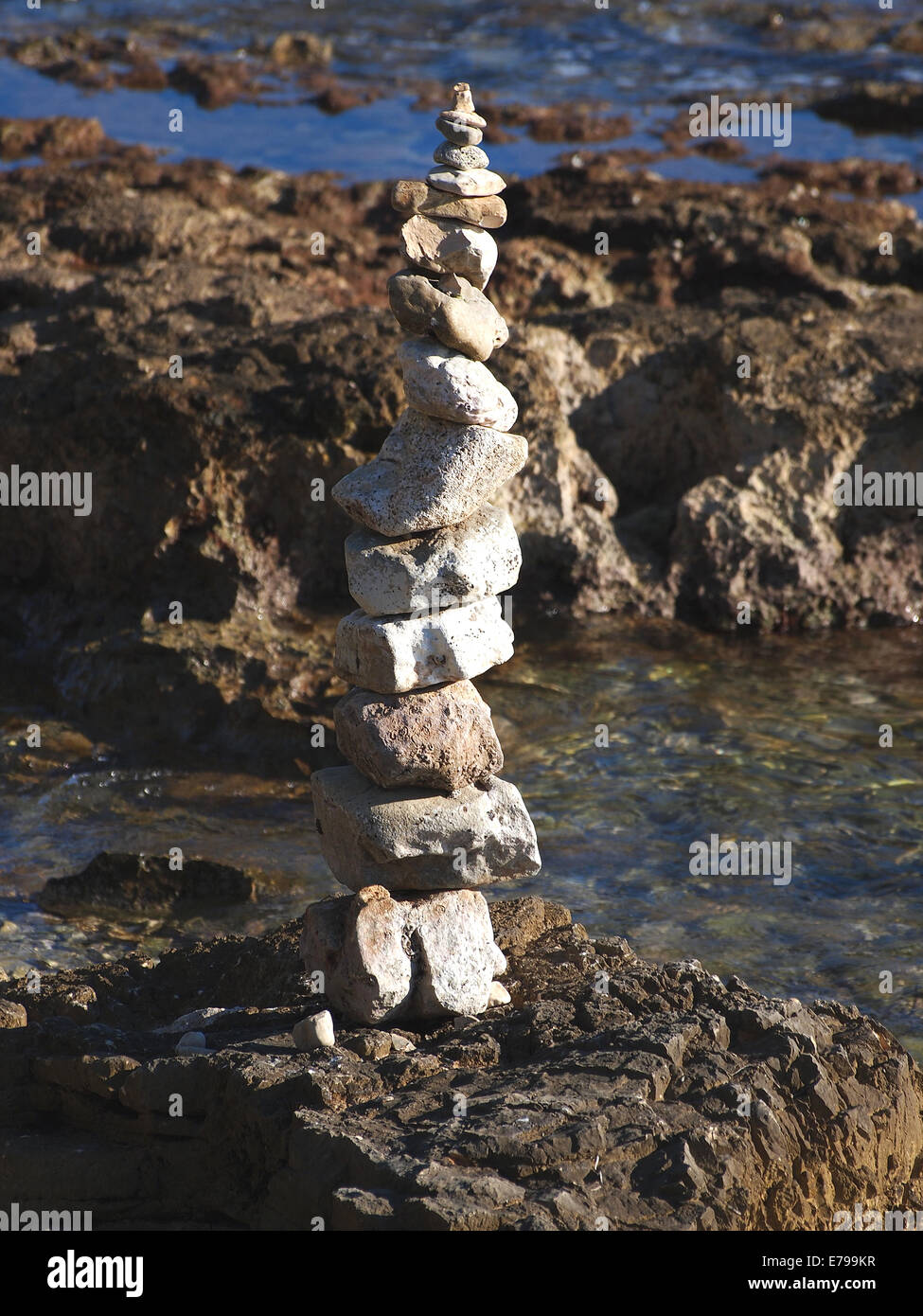 Pila di pietre rotonde su una riva del mare Foto Stock