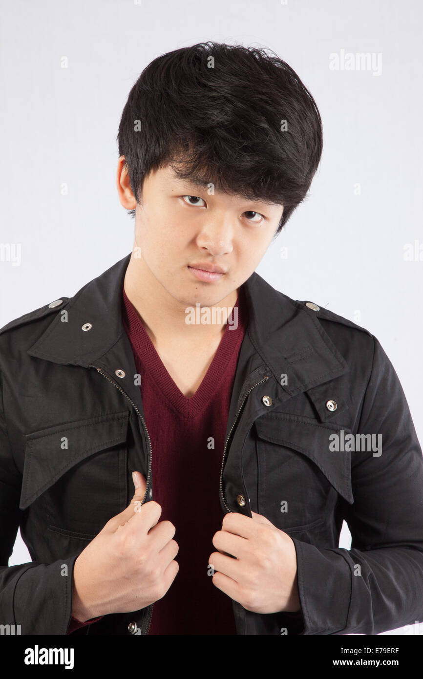 Bella East Asian uomo che indossa una camicia e con un espressione pensosa Foto Stock