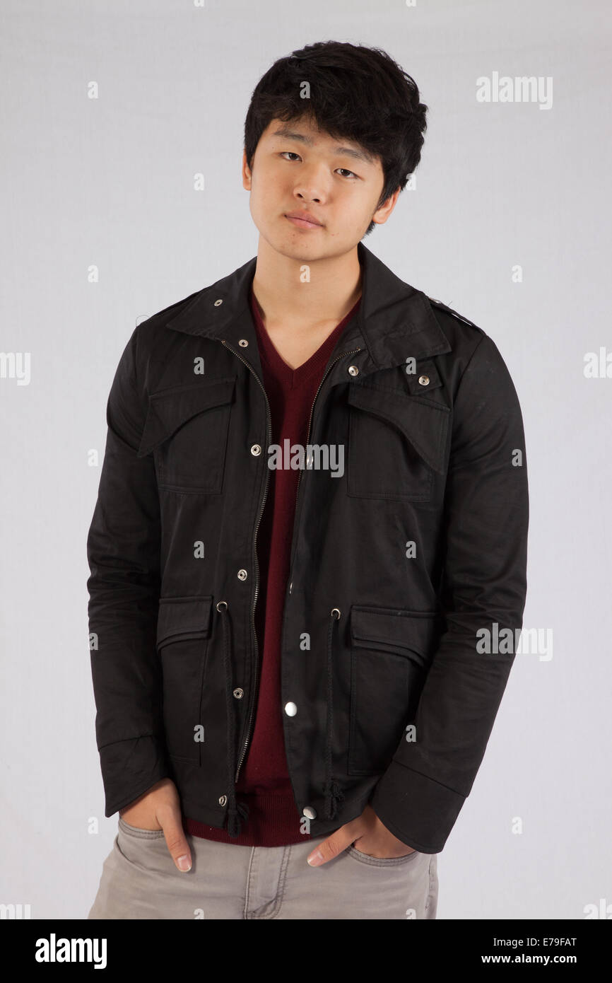 Bella East Asian uomo che indossa una camicia e con un espressione pensosa Foto Stock