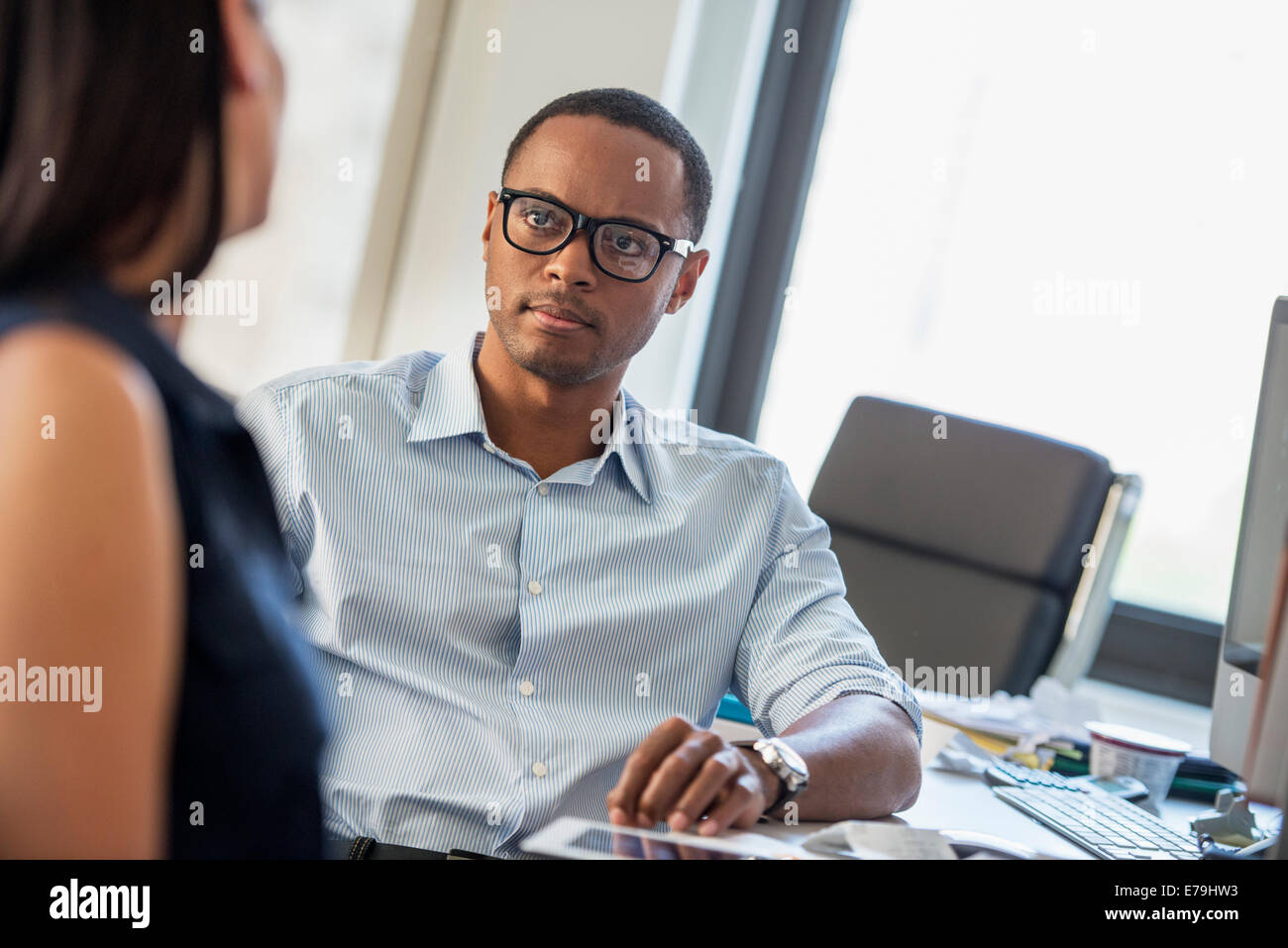 Un uomo e una donna parlano in un ufficio. Foto Stock