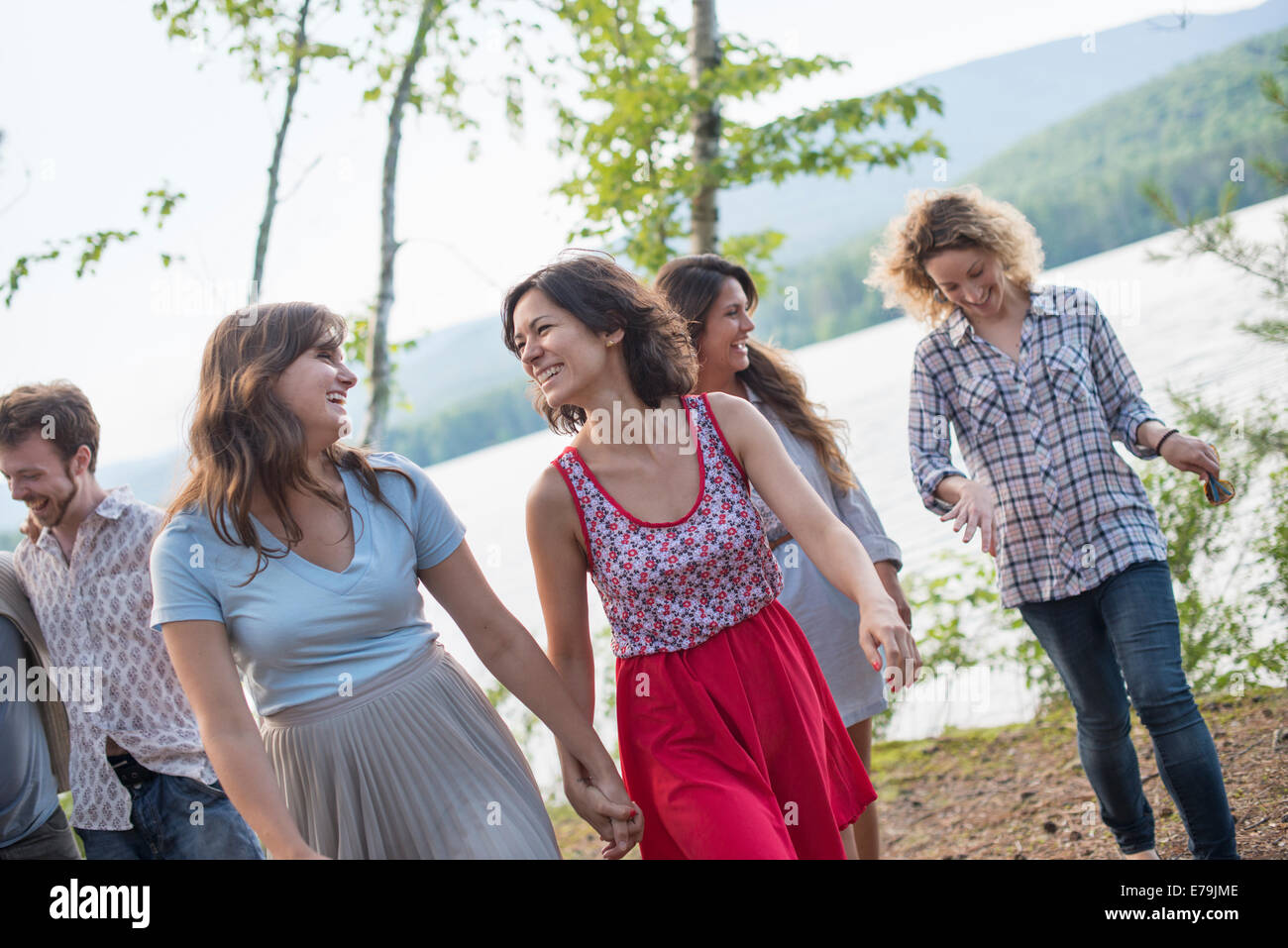 Un gruppo di persone che godono di una piacevole passeggiata da un lago. Foto Stock