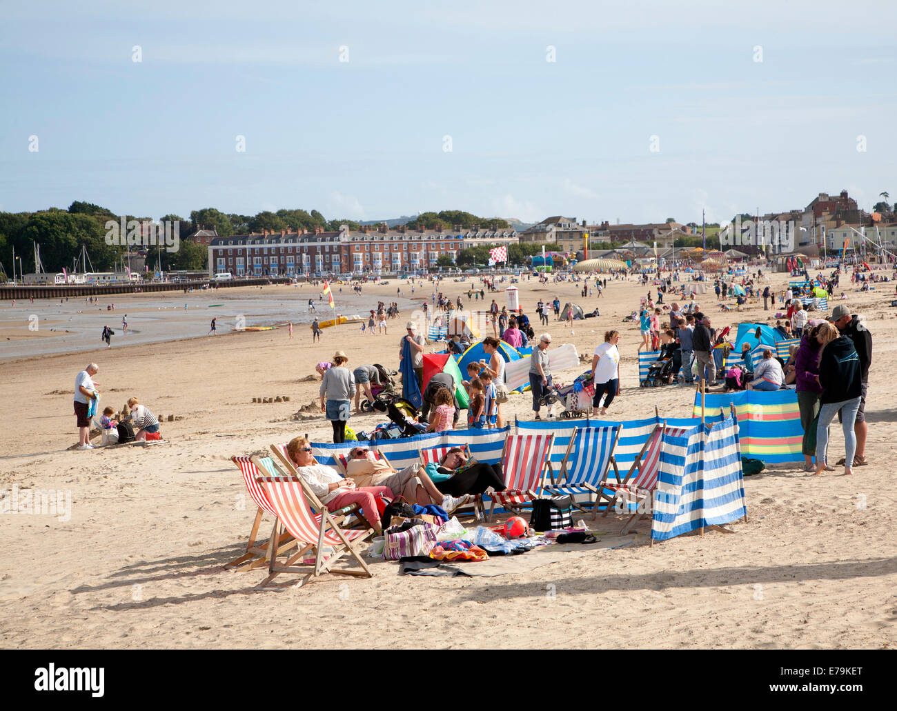 Vacanzieri godere di sole sulla spiaggia di sabbia a Weymouth Dorset, Inghilterra Foto Stock