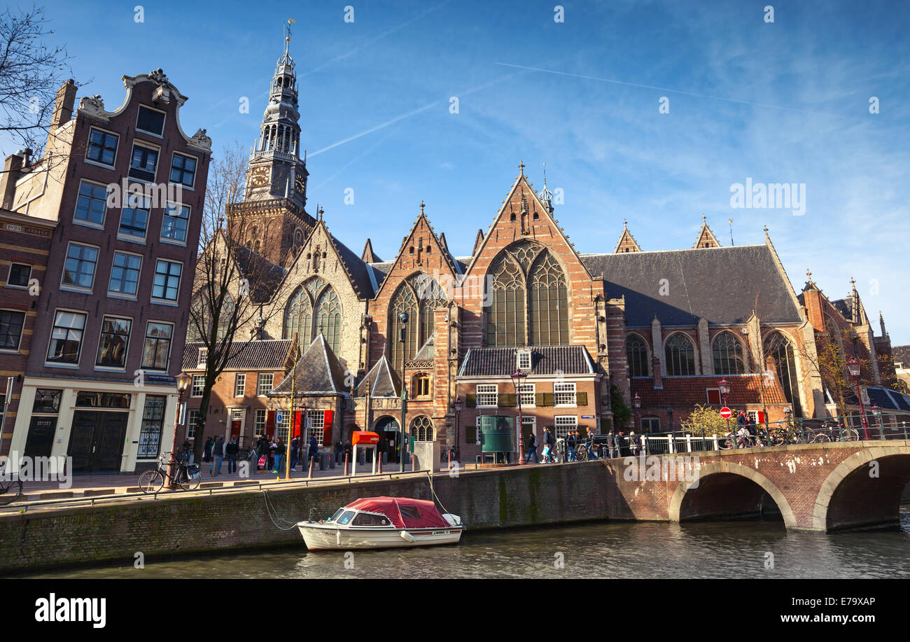 AMSTERDAM, Paesi Bassi - 19 Marzo 2014: Oude Kerk. Vecchia chiesa sulla costa del canale di Amsterdam. La gente comune a piedi sulla strada Foto Stock