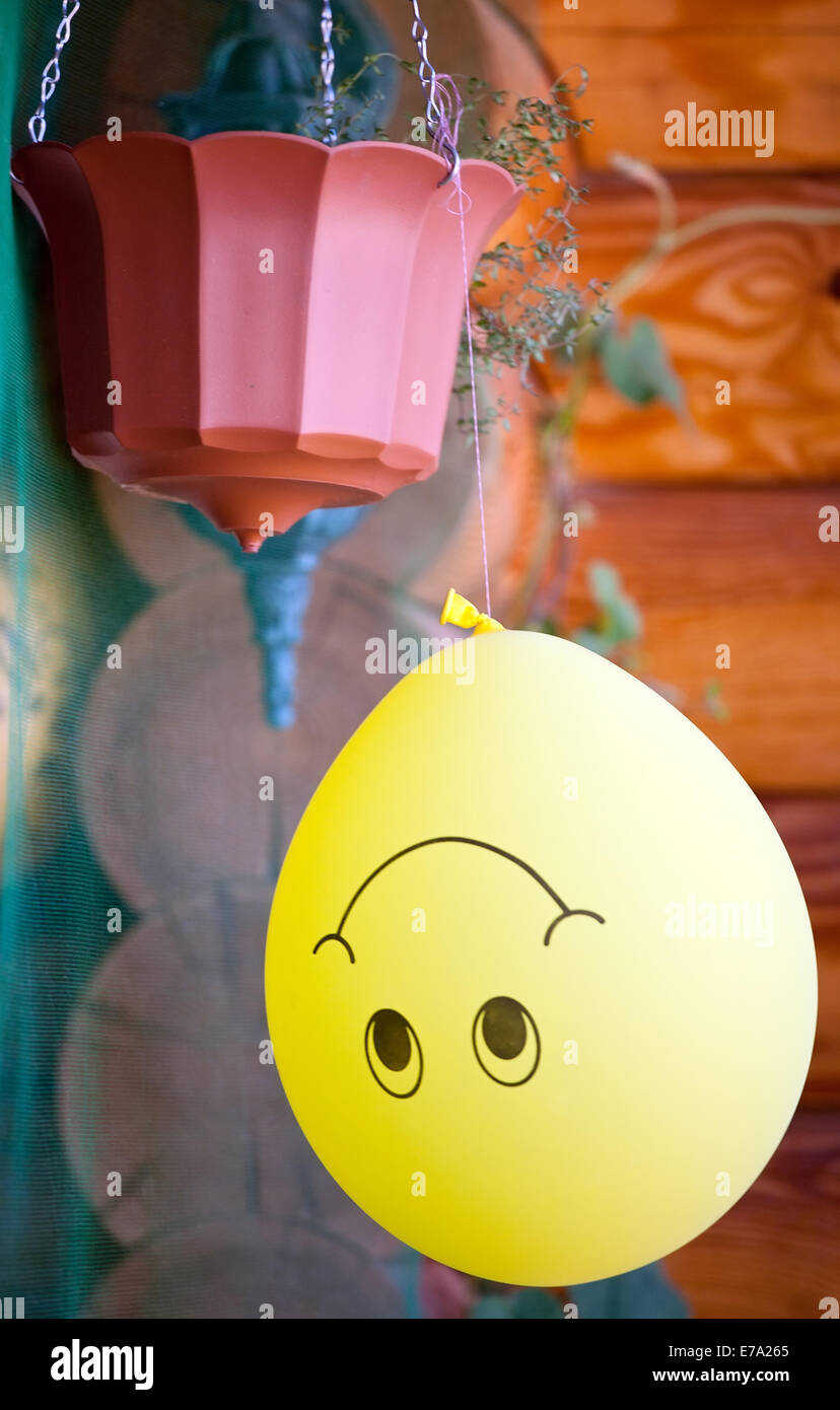 Grande sorriso giallo palloncino appesi a testa su tacchi Foto Stock