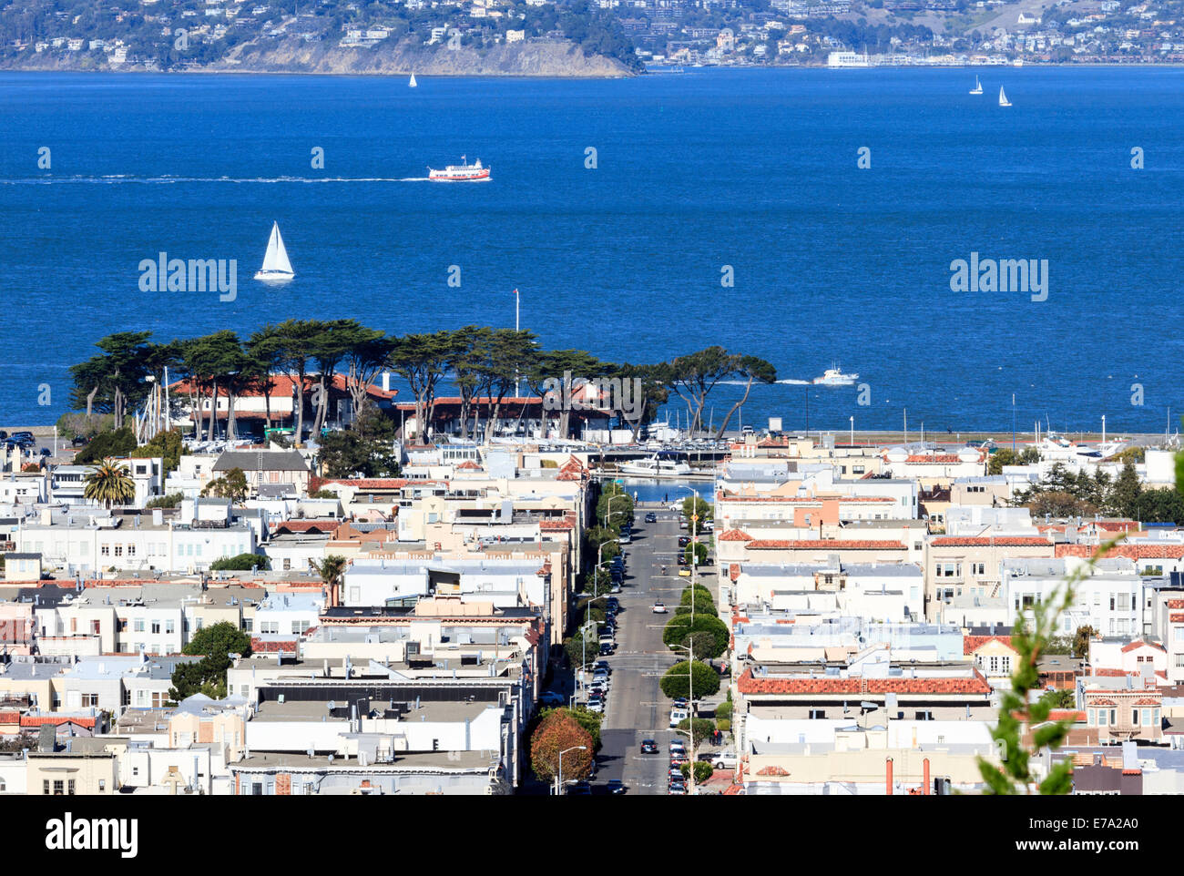 Guarda case lungo Broderick Street nel quartiere Marina di San Francisco con barche sulla Baia di San Francisco Foto Stock