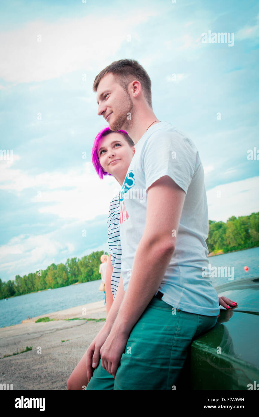 L uomo e la donna seduta su una barca capovolta sul fiume Foto Stock