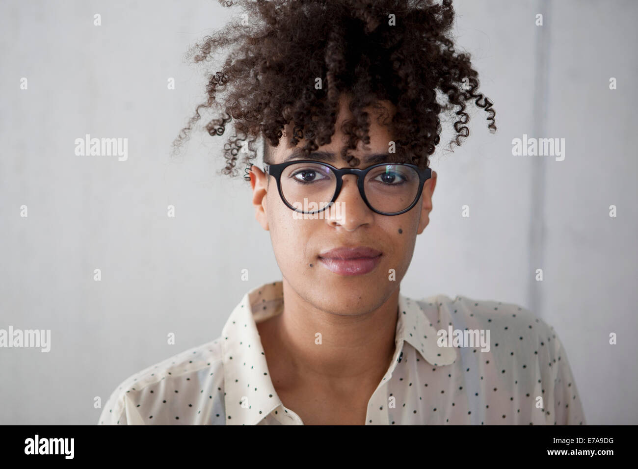 Ritratto di giovane donna con capelli ricci a casa Foto Stock