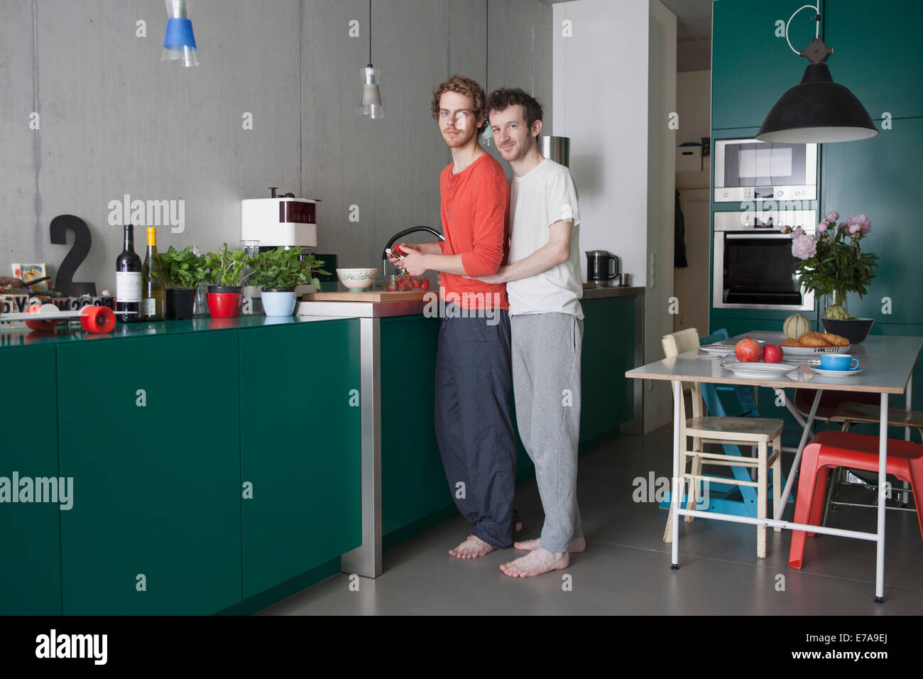 A piena lunghezza Ritratto di giovane Coppia gay in cucina Foto Stock