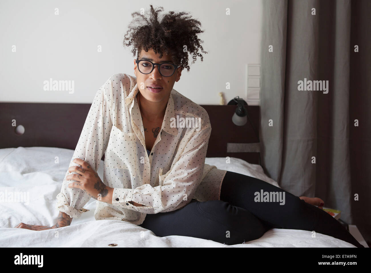 Ritratto di fiducioso donna seduta sul letto di casa Foto Stock