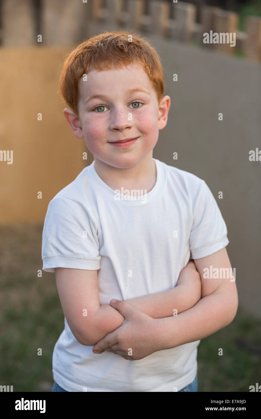 Ritratto di un giovane ragazzo con le braccia incrociate in cantiere Foto Stock