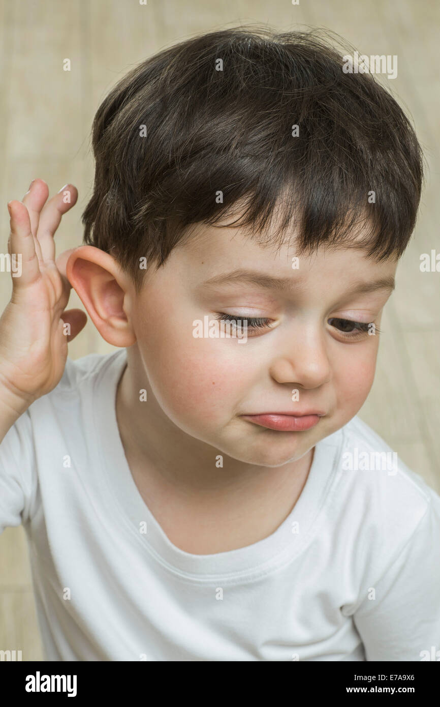 Carino ragazzo di graffiare la testa a casa Foto Stock