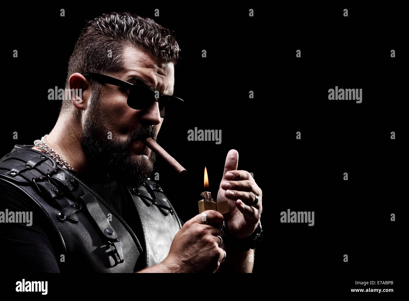 Badass biker accendere una sigaretta su sfondo nero Foto Stock