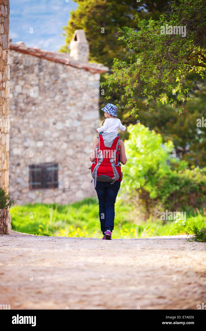 La donna porta turistica di suo figlio sulle spalle all'aperto Foto Stock