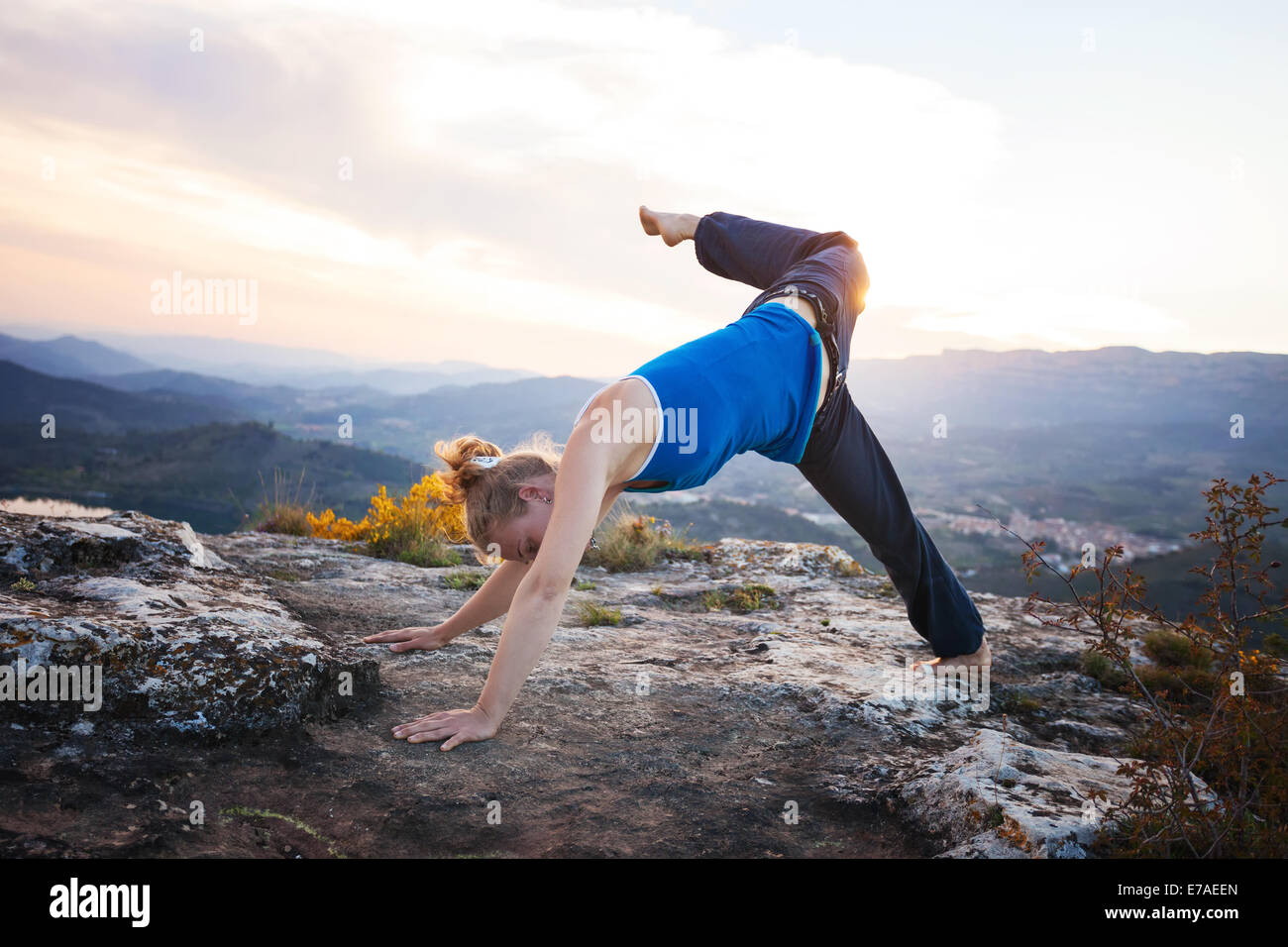 Giovane donna caucasica eseguendo il cane verso il basso lo yoga pone all'aperto Foto Stock