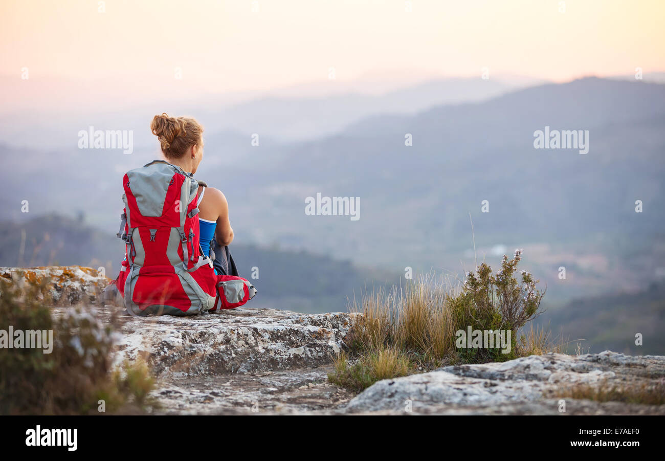 Donna seduta turistica sulla cima di una montagna Foto Stock