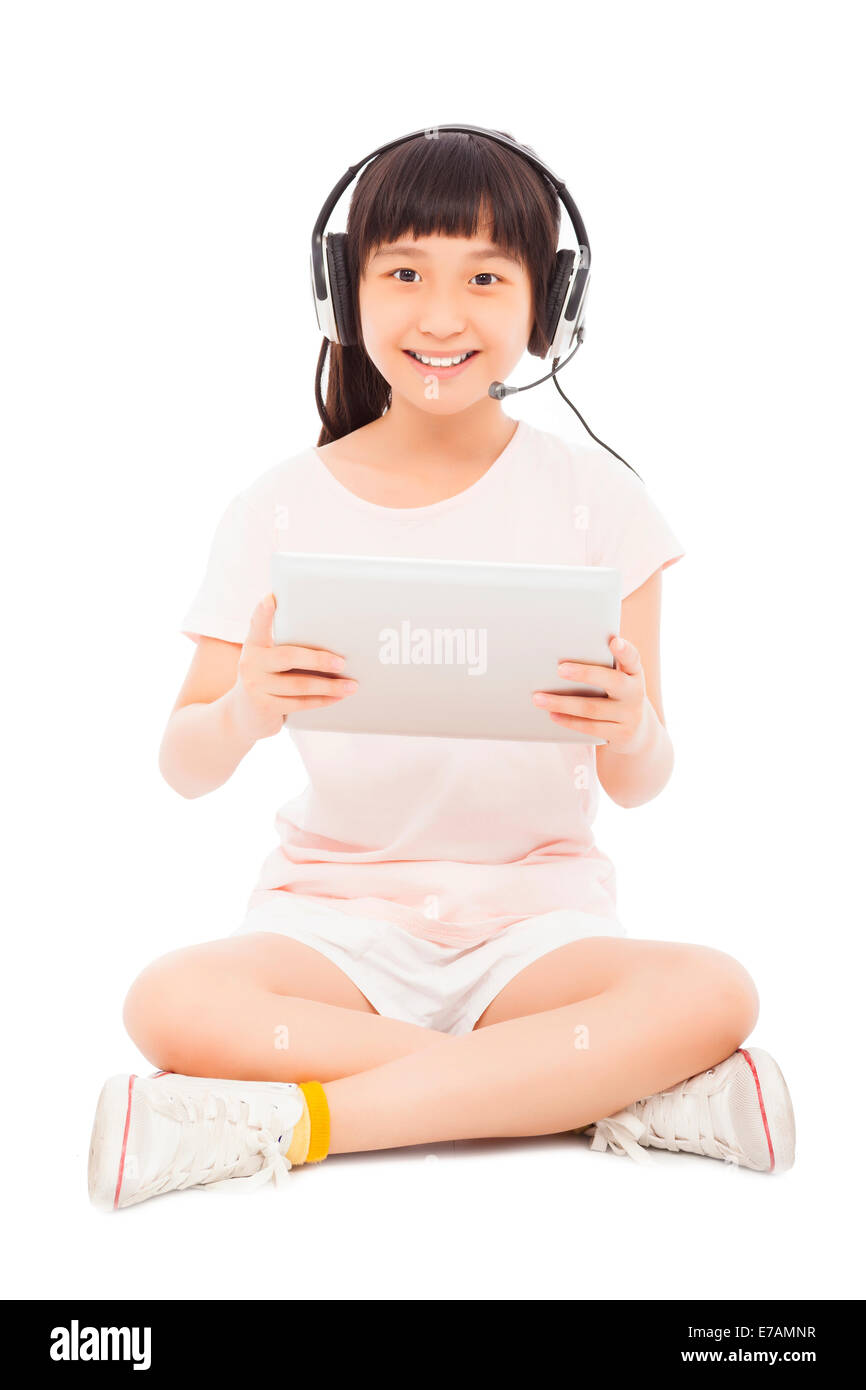 Poco sorridente ragazza seduta e tenendo un tablet con auricolare.isolati su sfondo bianco Foto Stock