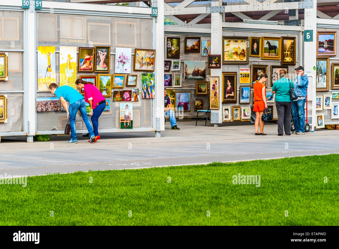 Mosca, Russia. Giovedì 7 Settembre 11, 2014. Vendita di arte di Mosca Museon park. La città di Mosca ha creato la cosiddetta struttura di vernissage, dove l'artista può vendere le loro belle arti all'aria aperta a Mosca Museon parco delle arti. I potenziali acquirenti guardare in maniera restrittiva a dipinti (sinistra) e parlare con il fornitore (a destra). Credito: Alex Immagini/Alamy Live News Foto Stock